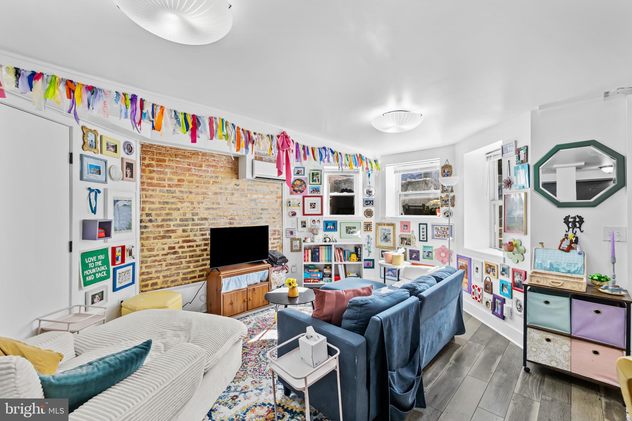 1021 Columbia Road Northwest Washington, DC 20001 - Photo 36 of 55 a living room with furniture a flat screen tv and a fireplace