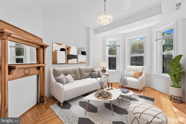 a living room with furniture potted plant and a large window
