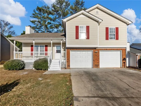 a view of a white house with large windows and a yard