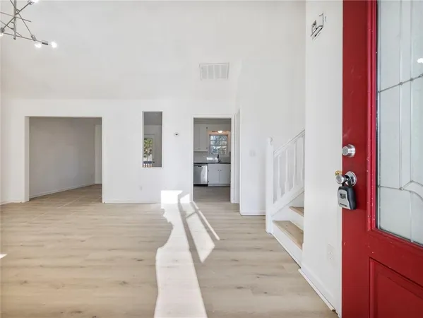 a view of a hallway with wooden floor and staircase