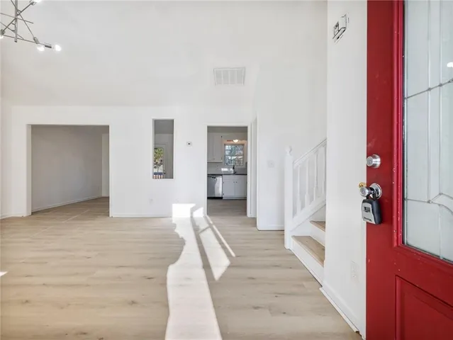 a view of a hallway with wooden floor and staircase