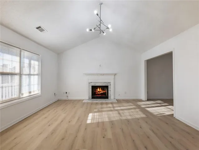 wooden floor fireplace and windows in an empty room