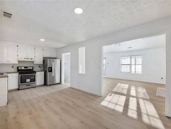 a kitchen with stainless steel appliances a refrigerator and a stove top oven