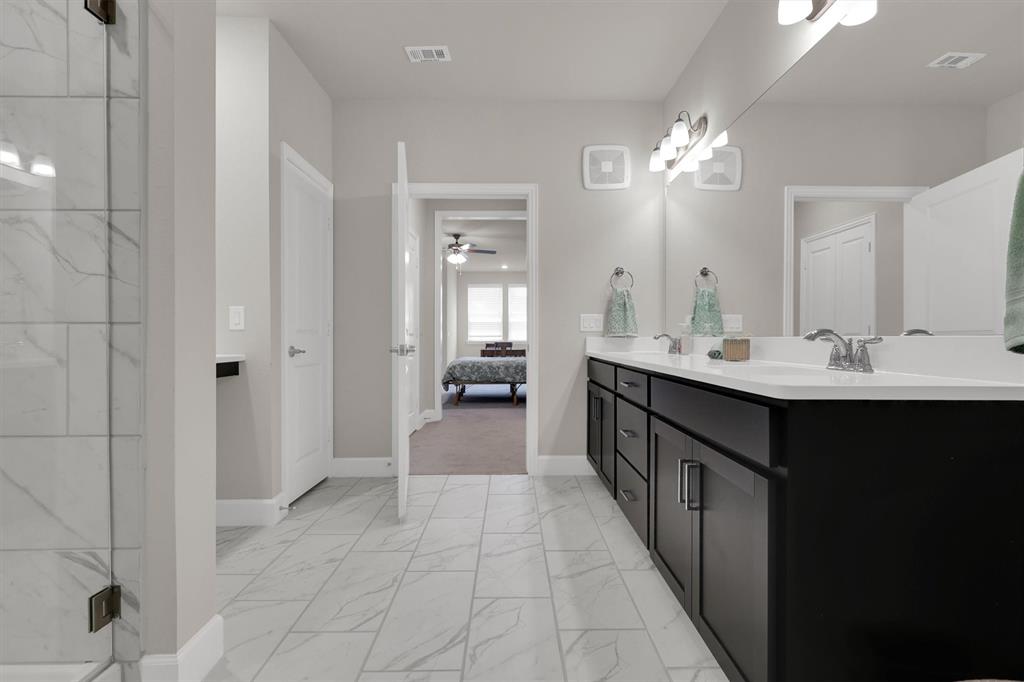 651 Watters Road, Unit 2105 Allen, TX 75013 - Photo 23 of 32 a en suite bathroom with a double vanity sink a mirror and a bathtub