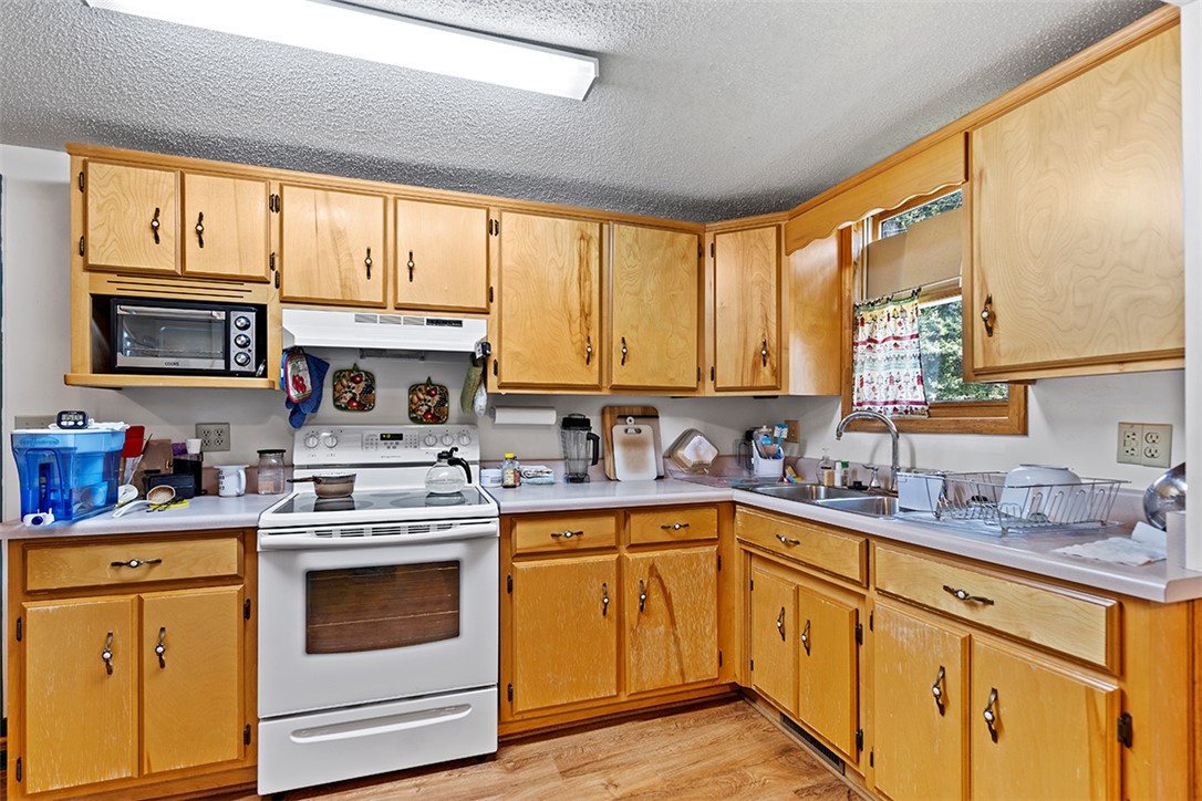 200 Louisiana Street Honea Path, SC 29654 - Photo 2 of 13 Functional kitchen with ample cabinet space, an electric range, and a sink with a window view.