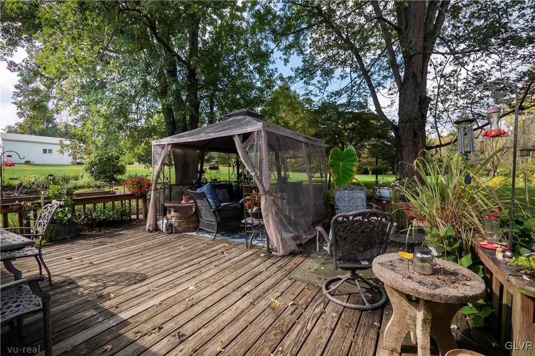 130 County Line Road Riegelsville, PA 18077 - Photo 33 of 40 a view of a patio with table and chairs barbeque potted plants and large tree