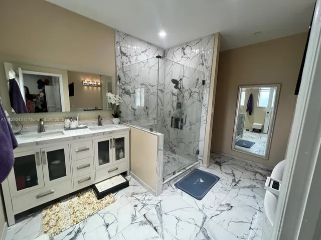 a bathroom with a double vanity sink toilet and shower
