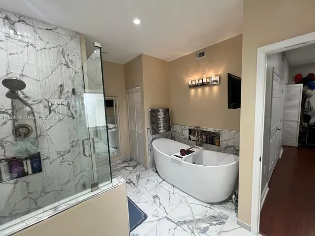 a spacious bathroom with a bathtub and shower