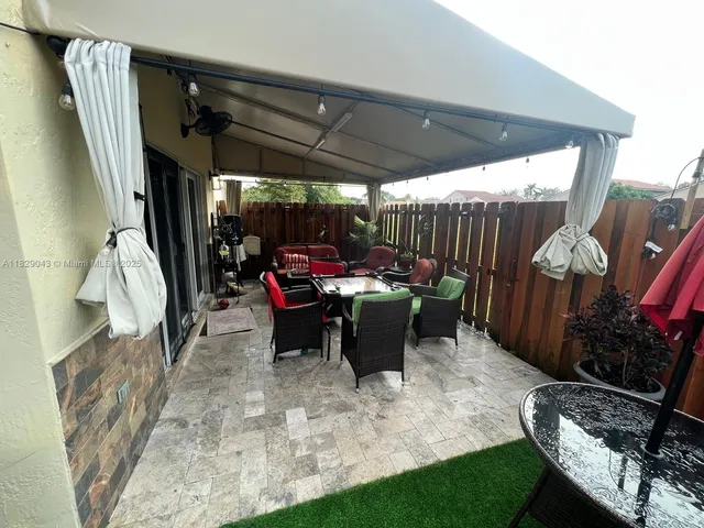 a view of a chairs and table in patio with a barbeque