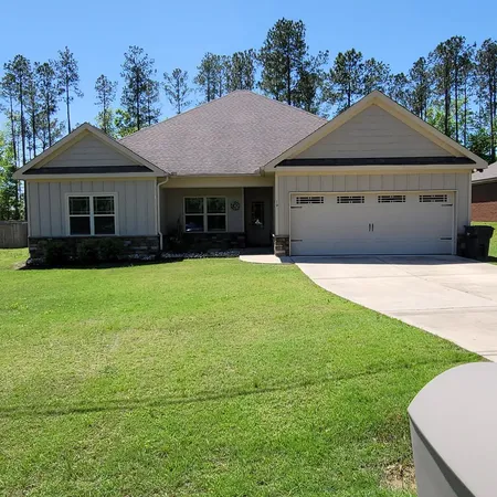 a front view of a house with yard and green space