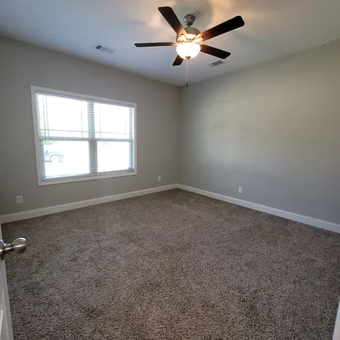 an empty room with a window and a fan