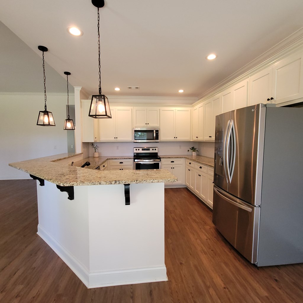 19 Fast Lane Seale, AL 36875 - Photo 4 of 18 a kitchen with kitchen island a counter top a refrigerator a sink and wooden floor