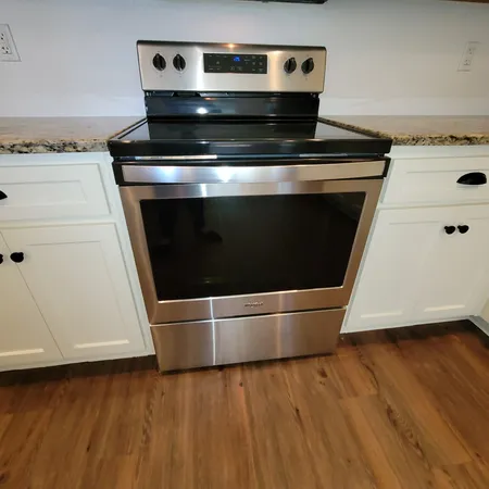 a stove top oven sitting inside of a kitchen