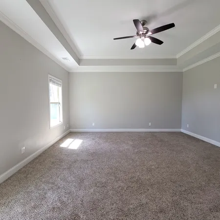 an empty room with a window and a ceiling fan