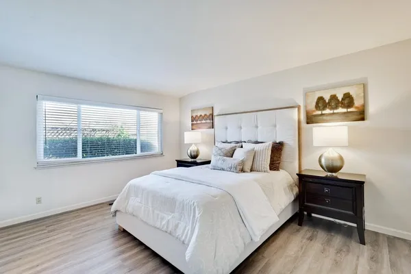 a bedroom with a bed and a painting on the wall