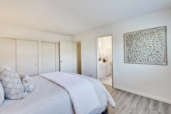 a bedroom with a bed and wooden floor