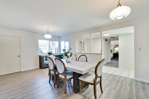 a dining room with furniture a chandelier and wooden floor