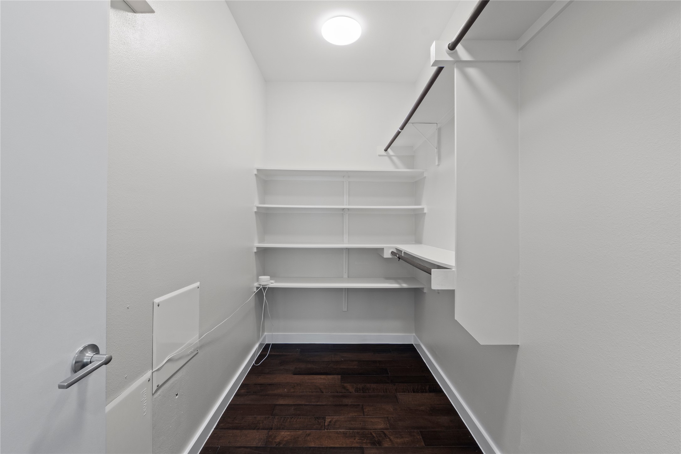 3001 Del Curto Road, Unit 35 Austin, TX 78704 - Photo 11 of 22 Walk-in closet featuring dark wood flooring, built-in shelving, and hanging rods for storage