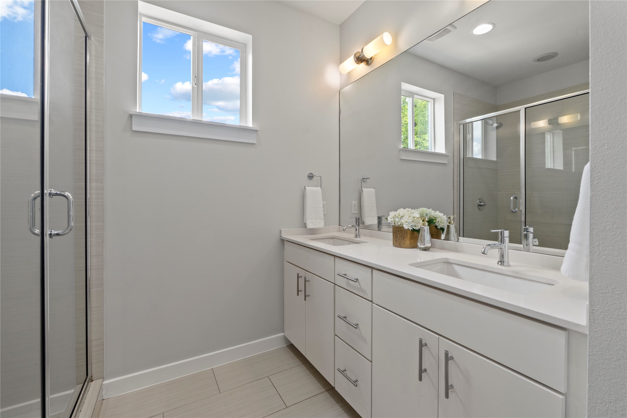 3001 Del Curto Road, Unit 35 Austin, TX 78704 - Photo 13 of 22 Bathroom featuring a large vanity with two sinks, a spacious walk-in shower with a glass door, and a window providing natural light
