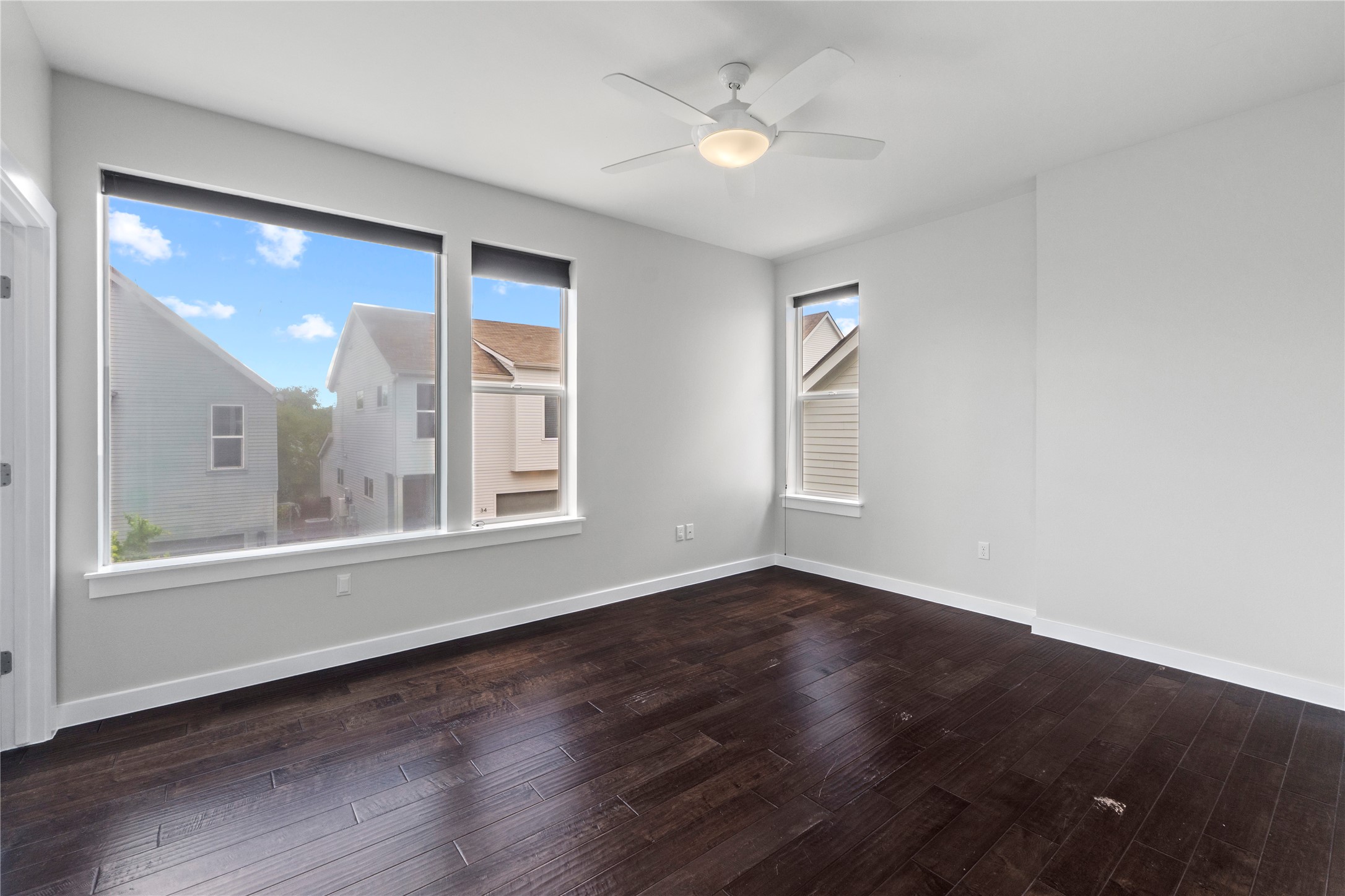 3001 Del Curto Road, Unit 35 Austin, TX 78704 - Photo 17 of 22 Spacious room featuring dark hardwood floors, white walls, and a contemporary ceiling fan with an integrated light