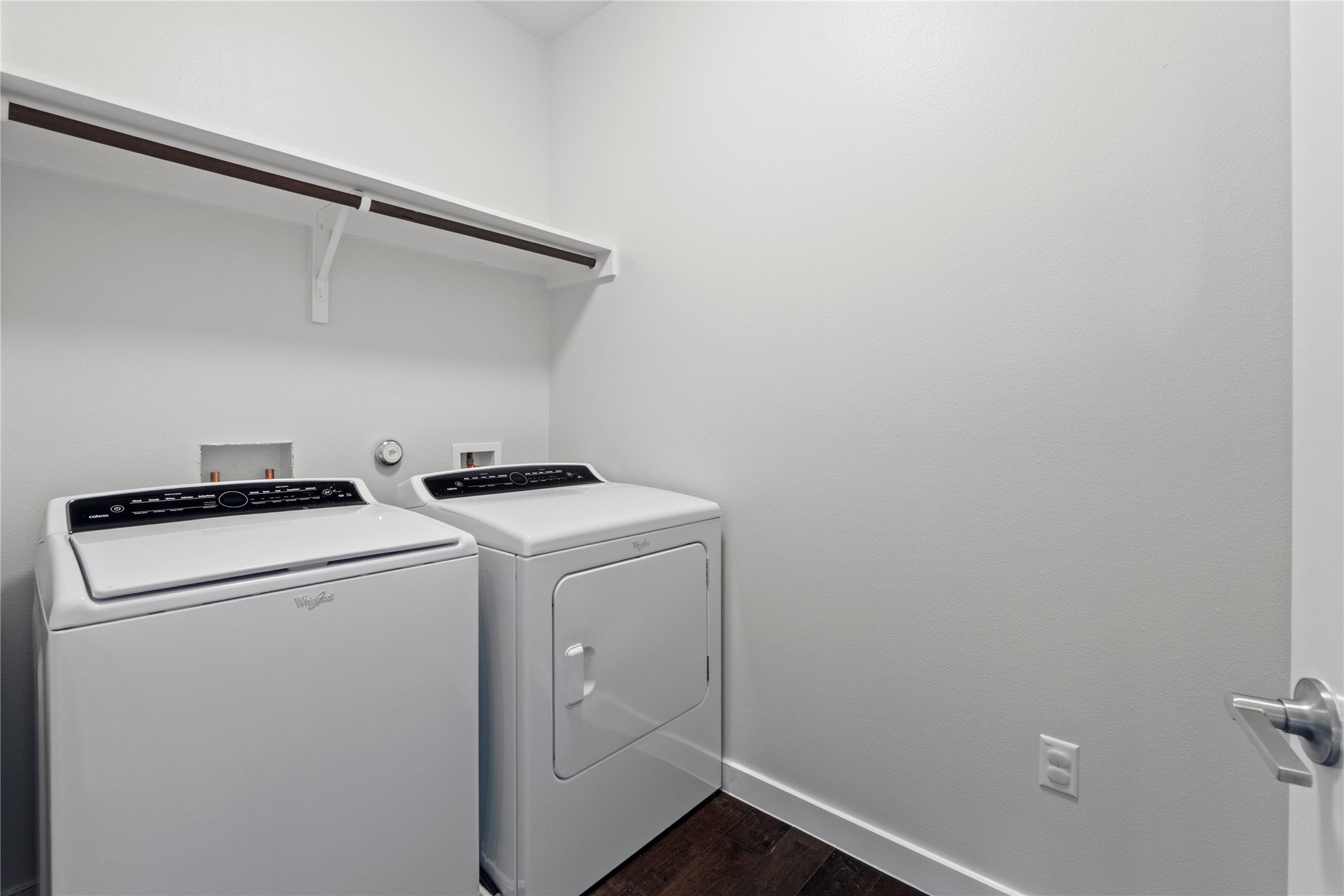 3001 Del Curto Road, Unit 35 Austin, TX 78704 - Photo 18 of 22 The property features a laundry area with a white shelf and hanging rod, complemented by dark wood flooring