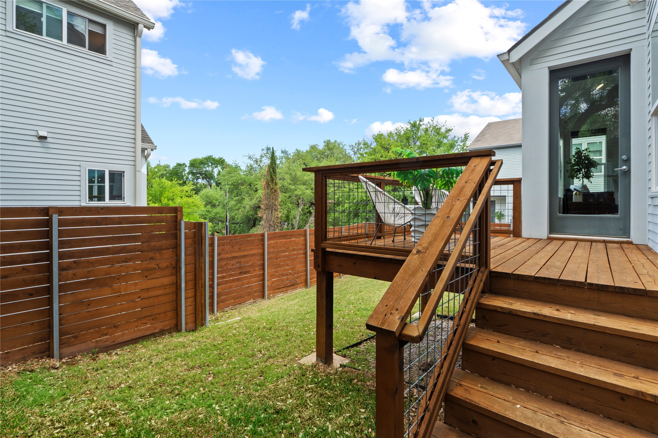 3001 Del Curto Road, Unit 35 Austin, TX 78704 - Photo 20 of 22 The property features an elevated wooden deck with steps and a contemporary railing design, overlooking a manicured lawn area