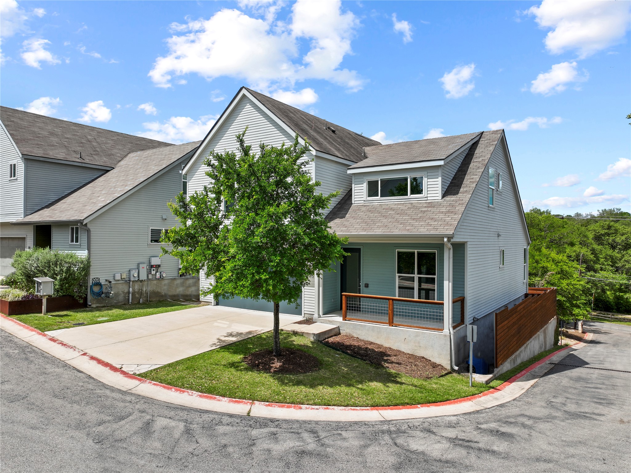 3001 Del Curto Road, Unit 35 Austin, TX 78704 - Photo 2 of 22 The property features a light blue exterior with white trim, a gabled roof, and an inviting front porch with a wooden railing
