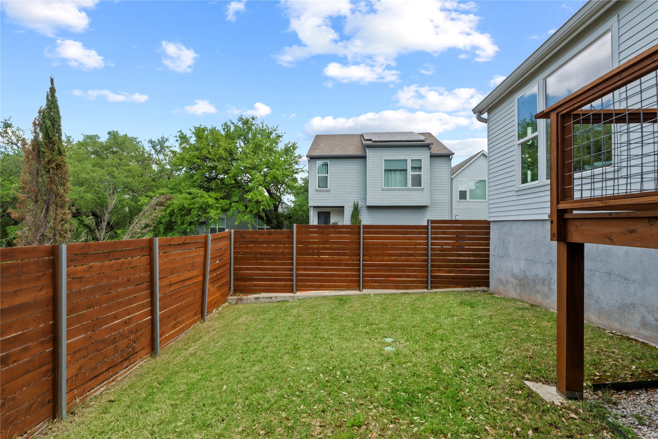 3001 Del Curto Road, Unit 35 Austin, TX 78704 - Photo 21 of 22 The property features a private yard with a well-maintained lawn and a horizontal slat wooden fence