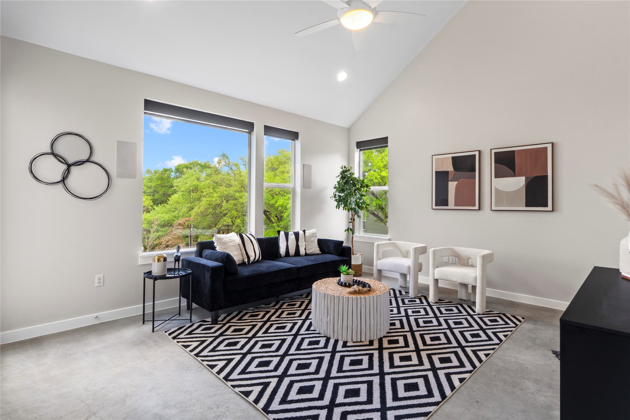 3001 Del Curto Road, Unit 35 Austin, TX 78704 - Photo 3 of 22 Living area featuring large windows with views of green trees, a vaulted ceiling, and a ceiling fan
