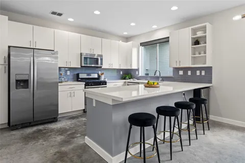a kitchen with a sink stainless steel appliances and white cabinets
