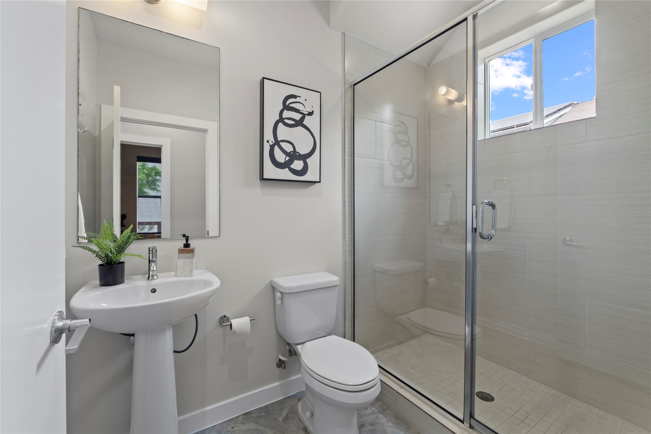 3001 Del Curto Road, Unit 35 Austin, TX 78704 - Photo 10 of 22 Bathroom featuring a pedestal sink, a toilet, and a glass-enclosed shower with a window