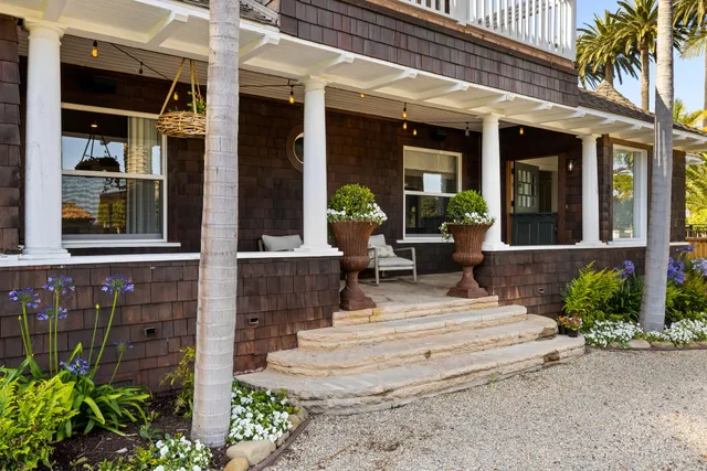 a view of a building with potted plants and a bench