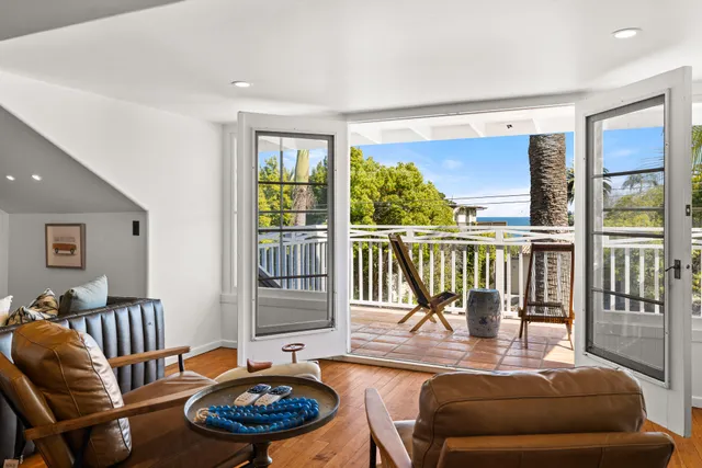a large bedroom with a bed and wooden floor