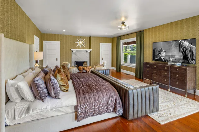 a living room with furniture kitchen view and a wooden floor