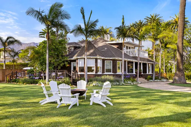 a front view of a house with garden and sitting area