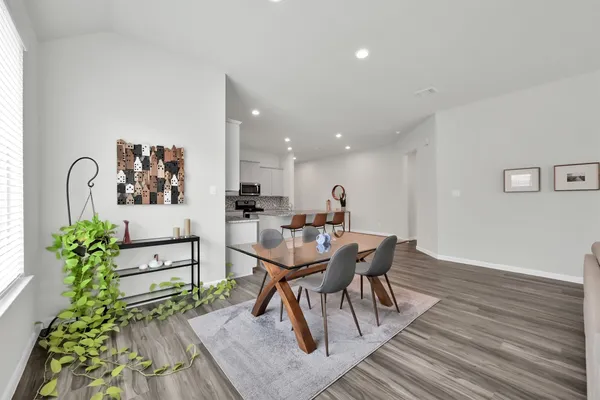 a dining room with furniture and wooden floor