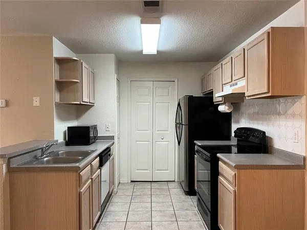 a kitchen with a refrigerator and a stove top oven