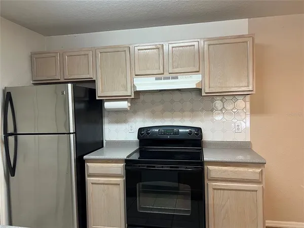 a kitchen with cabinets and stainless steel appliances