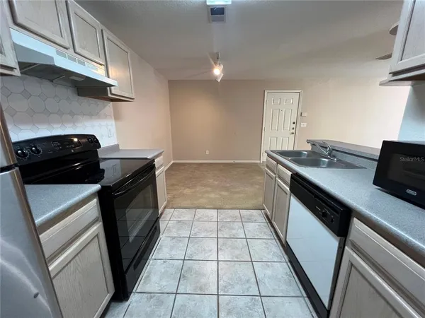 a kitchen with a sink and a stove top oven