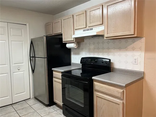 a kitchen with stainless steel appliances granite countertop white cabinets and refrigerator