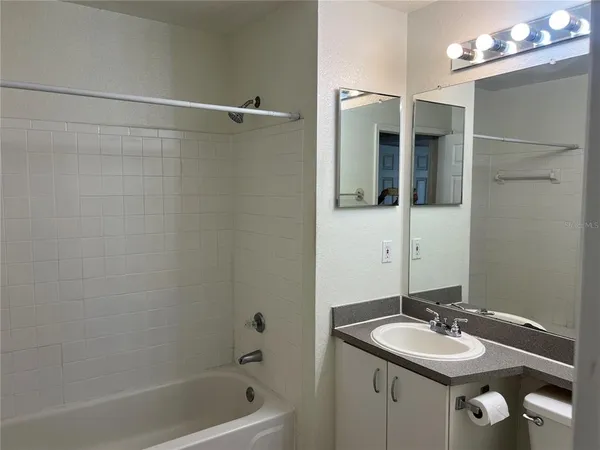 a bathroom with a granite countertop sink mirror and shower