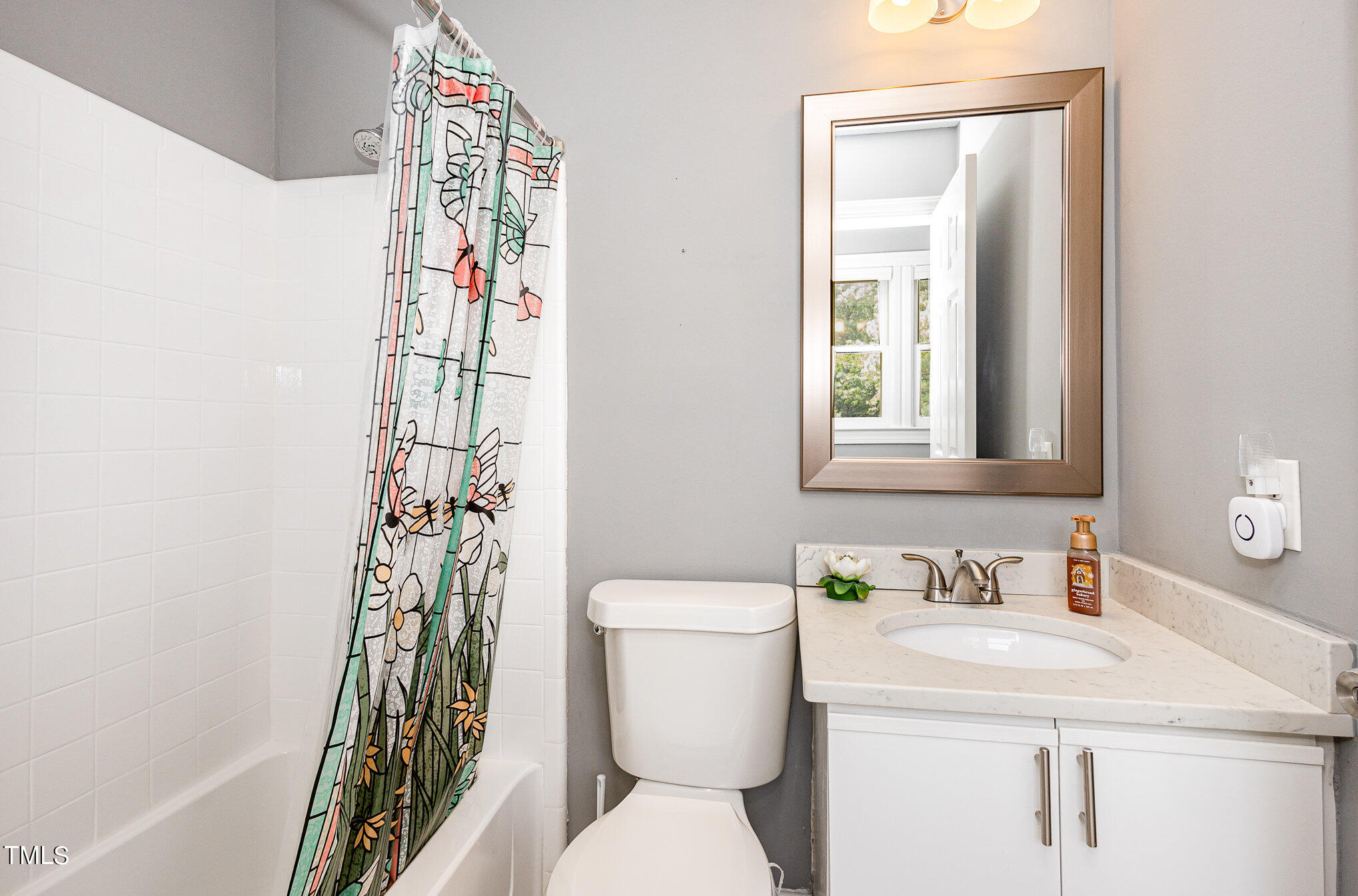 7040 Sandy Forks Road, Unit 203 Raleigh, NC 27615 - Photo 27 of 30 a bathroom with a sink a toilet and a mirror