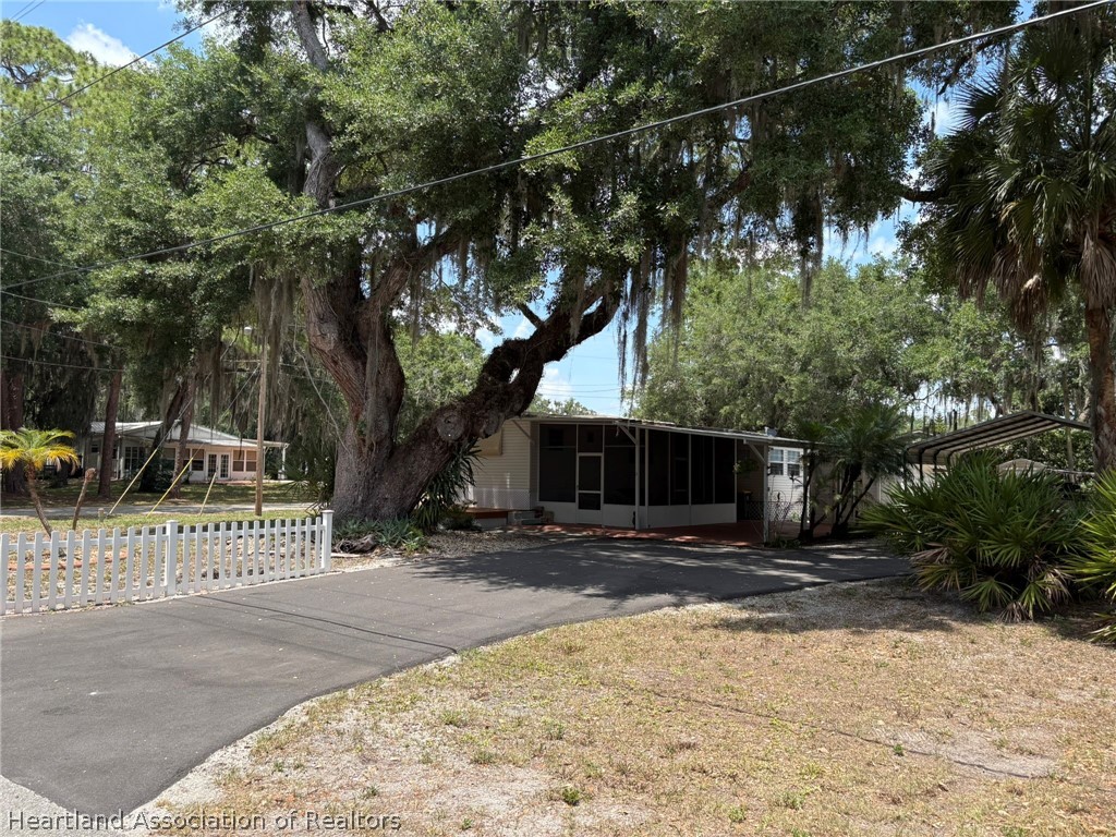 7938 Elliott Road Sebring, FL 33876 - Photo 1 of 20 a pathway of a house with a bench in front of it