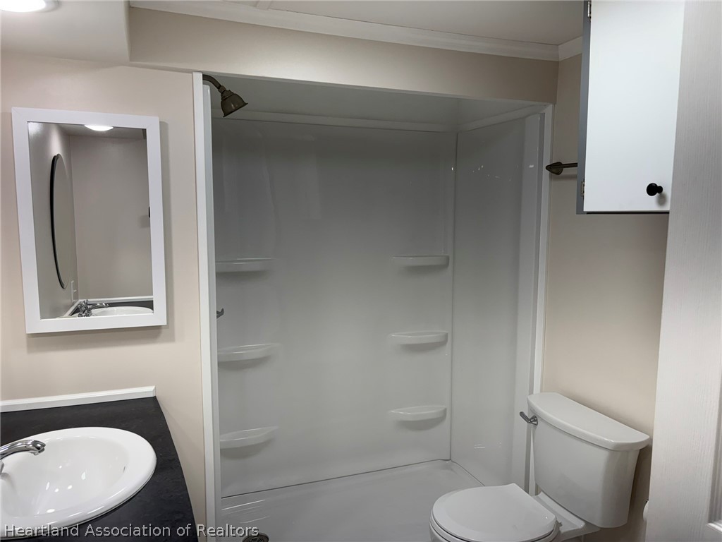 7938 Elliott Road Sebring, FL 33876 - Photo 12 of 20 a bathroom with a toilet sink and mirror