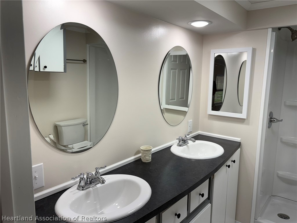 7938 Elliott Road Sebring, FL 33876 - Photo 13 of 20 a bathroom with a double vanity sink and a mirror