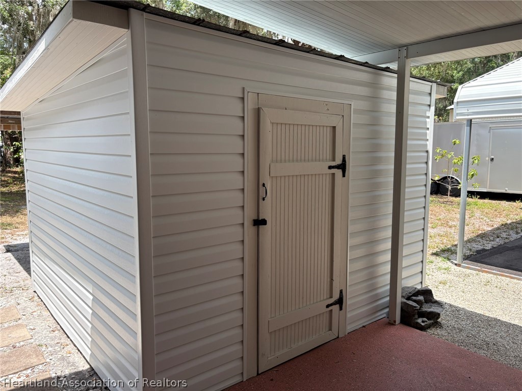 7938 Elliott Road Sebring, FL 33876 - Photo 19 of 20 a view of a door and a chair in the balcony