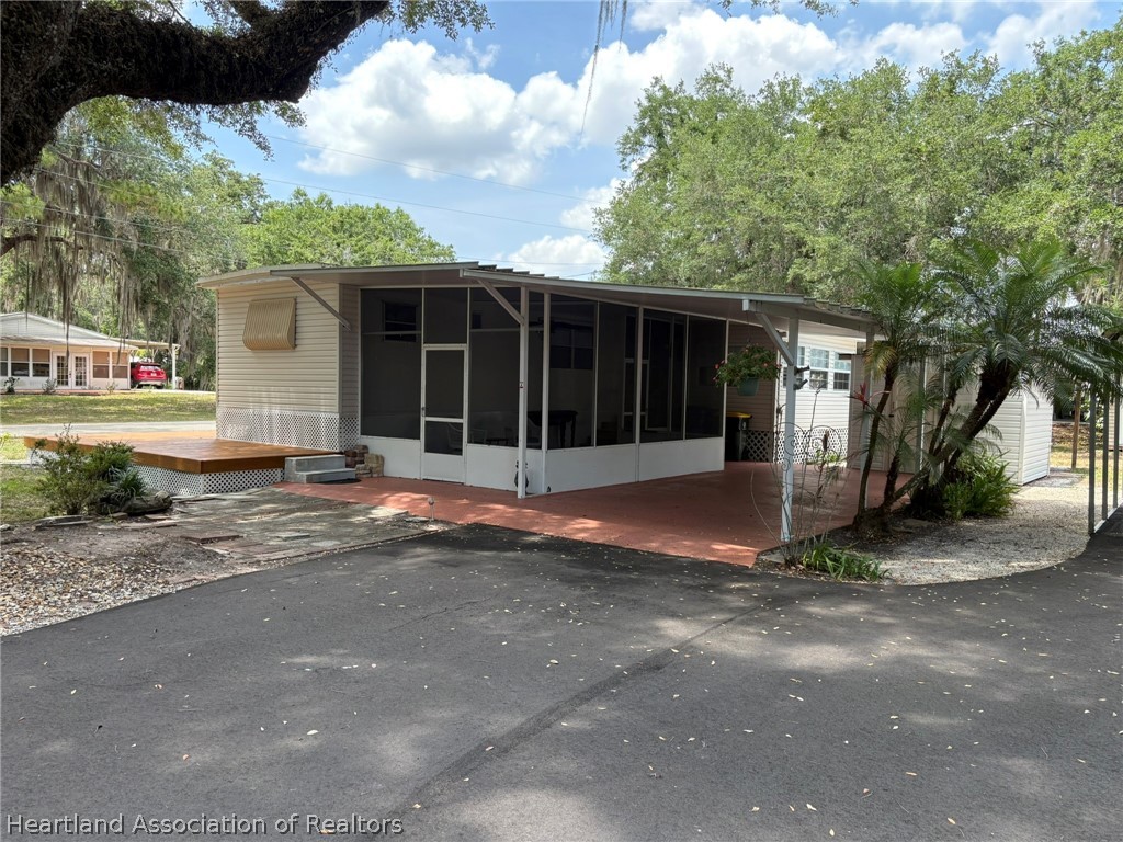 7938 Elliott Road Sebring, FL 33876 - Photo 2 of 20 a house with trees in the background