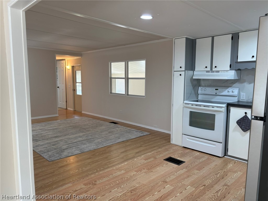 7938 Elliott Road Sebring, FL 33876 - Photo 6 of 20 a view of a kitchen with wooden floor and electronic appliances