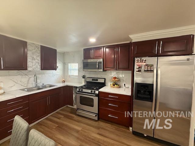 111 East Simplot Boulevard Caldwell, ID 83605 - Photo 7 of 17 Kitchen featuring wood-finish cabinetry, light-toned countertops, a stainless steel gas range, and a stainless steel refrigerator