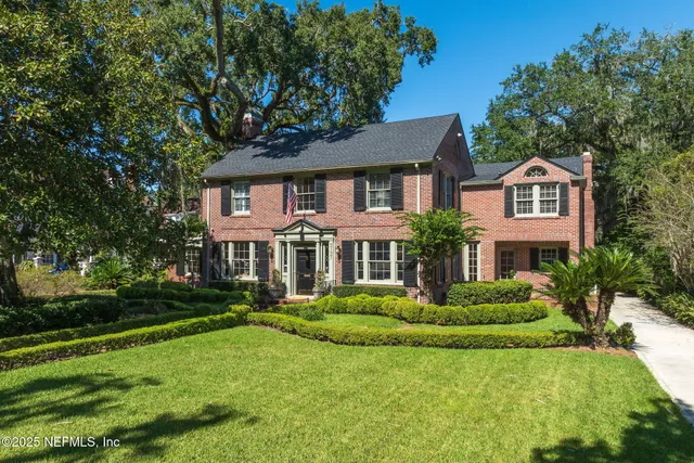 a view of a house with a big yard and large trees